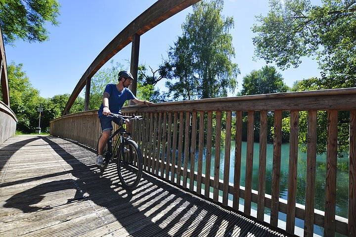 Blaustein-RadfahrerAufEinerBrücke-Donau-Fahrrad-JensBurkert