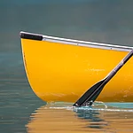 An energetic stroke sends a canoe gently down the stream.